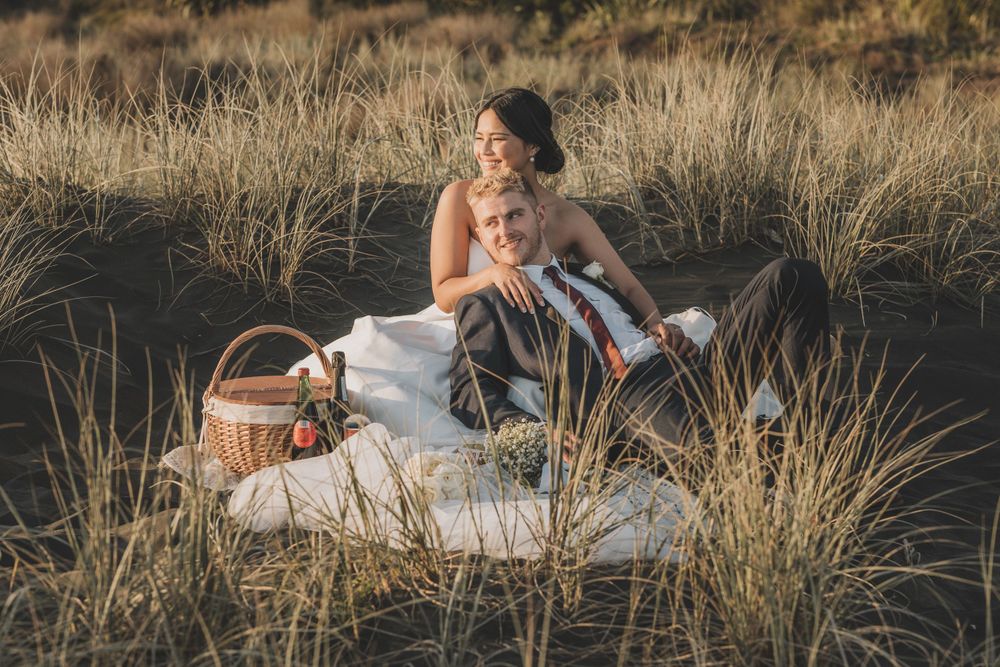 Picnic couple shot at Castaway Resort wedding, Karioitahi Beach: cross-cultural wedding, elopement. Wedding Photographer