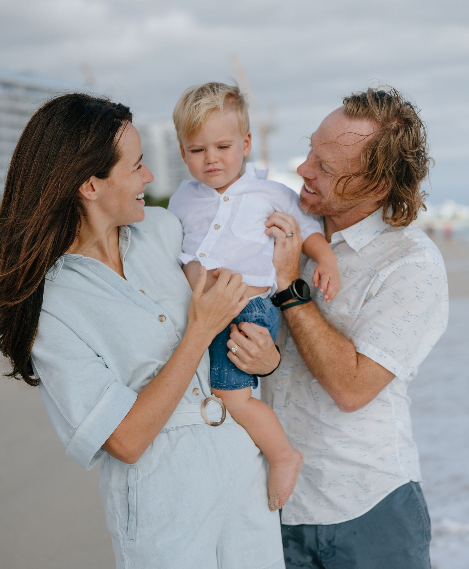 A family shares a tender moment together while enjoying time outdoors on an overcast day.