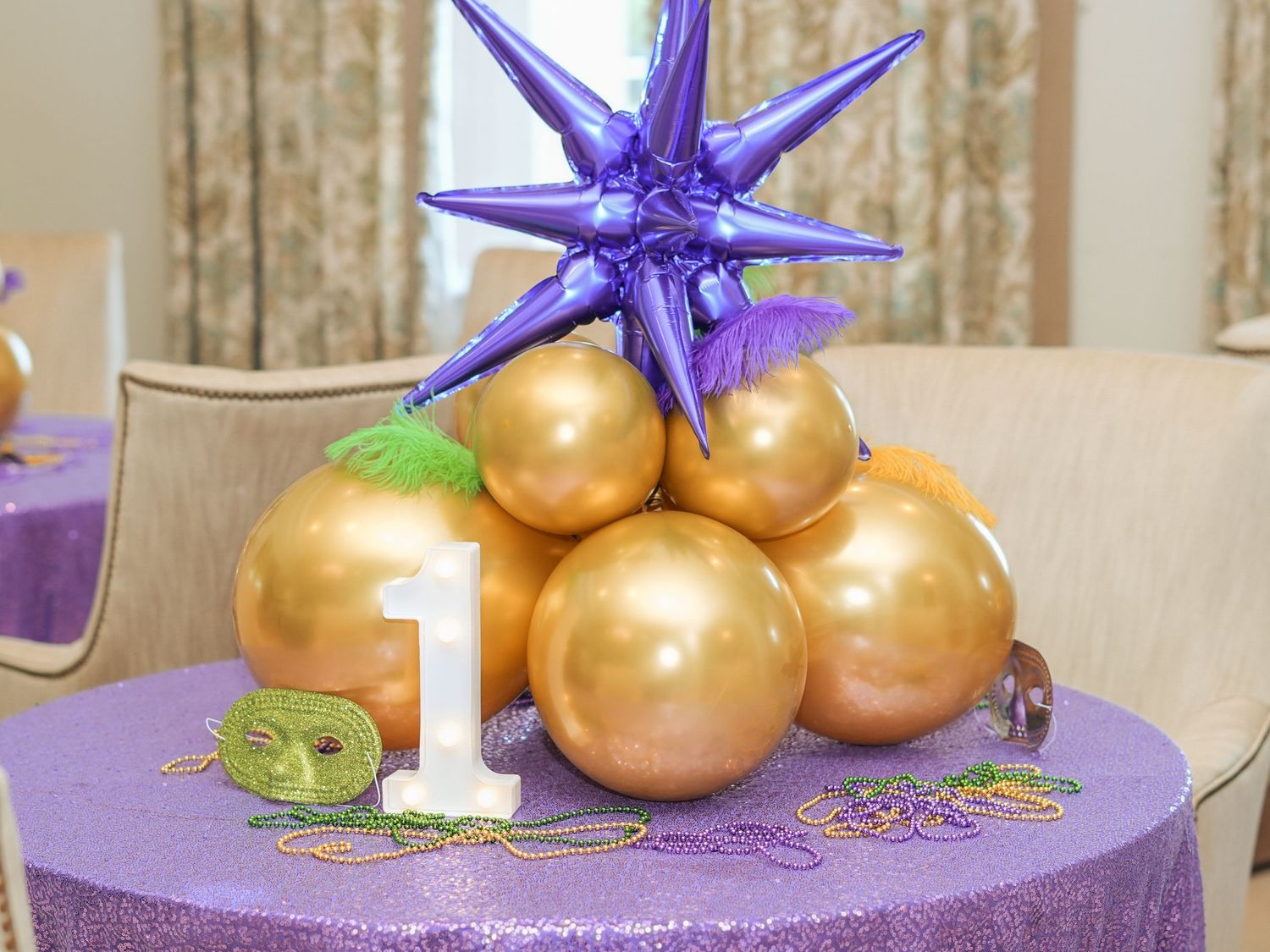 Purple star topper on gold balloon arrangement for first birthday party decoration.
