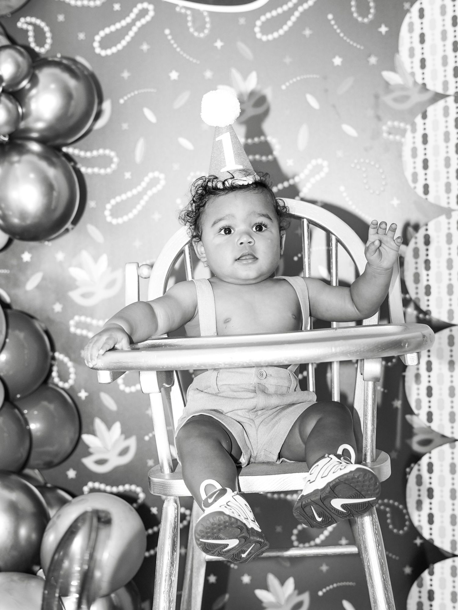 Black and white portrait of celebration setup with balloons and decorative lighting.