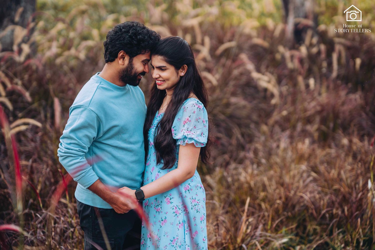 Romantic couple embracing in field with rustic brown grass background.