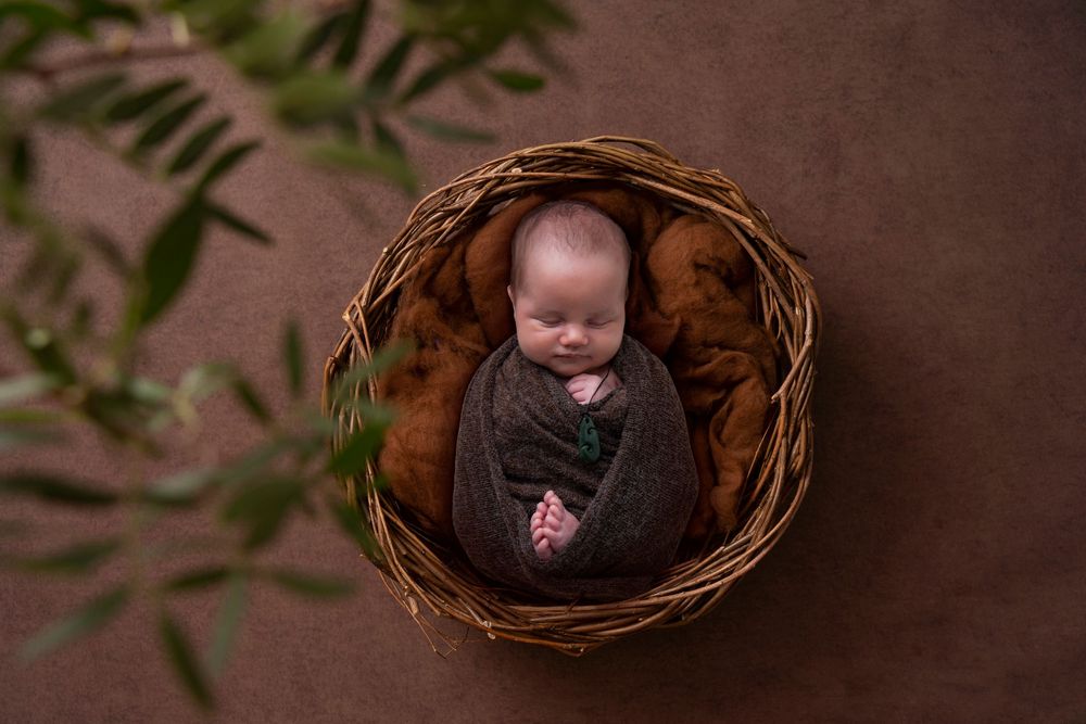 Newborn photographer Gold Coast safely posing baby in neutral wrap.