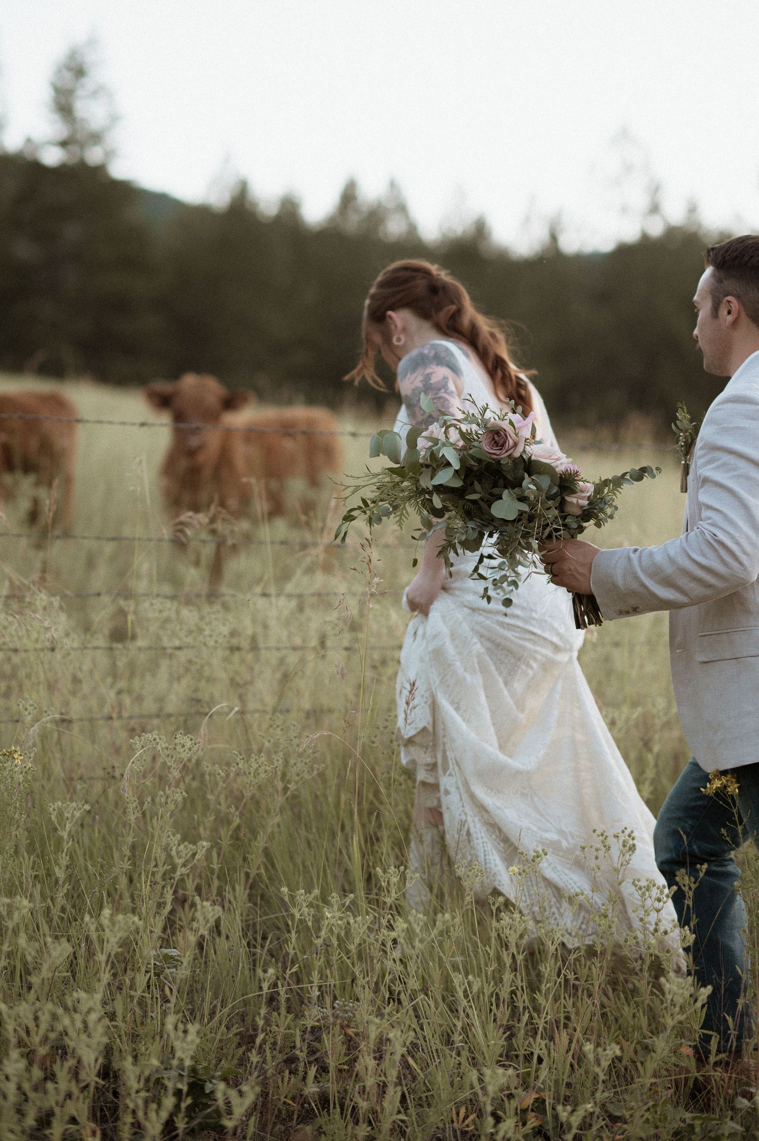 Bride and groom in field with cows