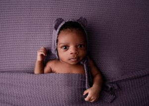 newborn on purple backdrop - Fort Worth Newborn Photoshoot