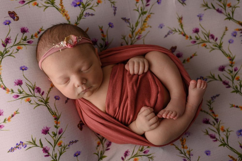 Newborn girl swaddled during newborn portrait session in a professional newborn studio in Arlington Texas