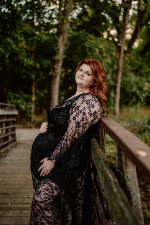 plus size pregnant mom posing on bridge during her professional portrait session