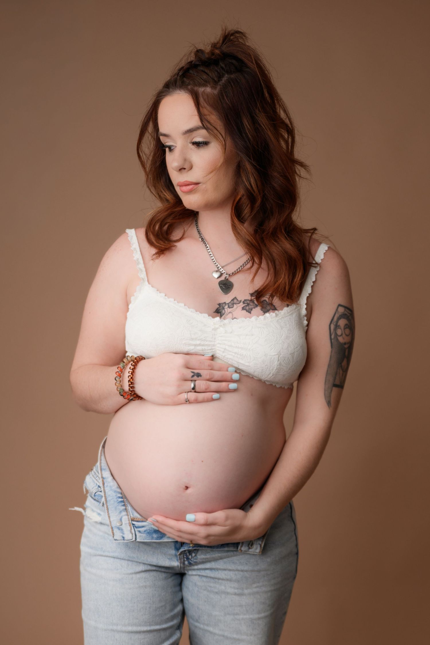 pregnant woman posing with hand on belly during a studio maternity session in Mansfield Texas