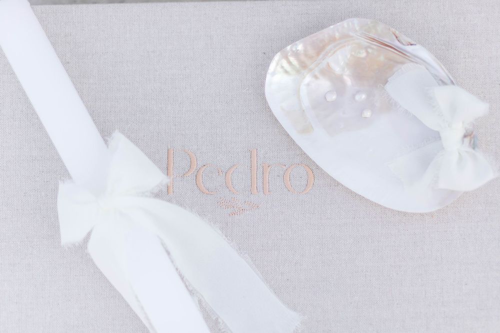 White satin baby shoes with bows tied on them.
