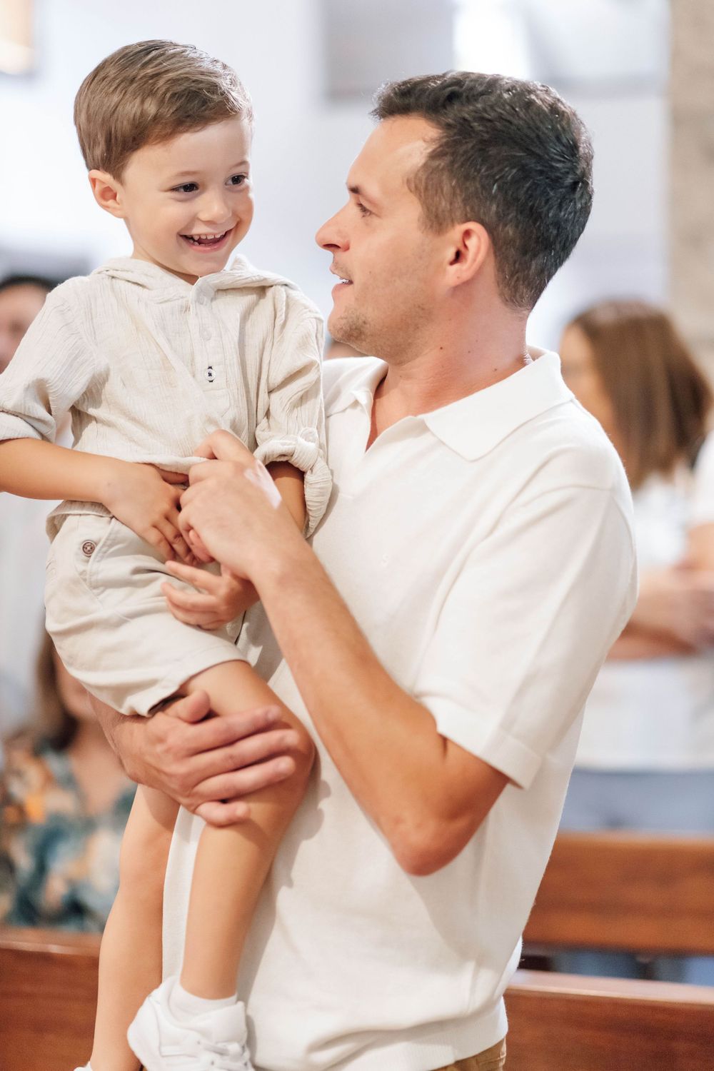 A heartwarming moment between parent and child dressed in white at a special event.