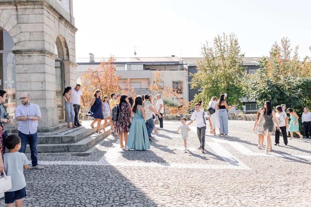 People gathered outside a stone building for a special event on a sunny day.