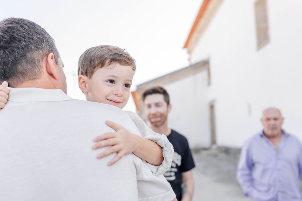 A joyful gathering of family members outdoors near a white building.