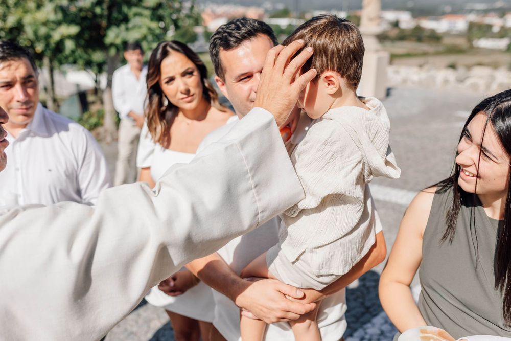 A group celebrating outdoors in white attire with a small child.