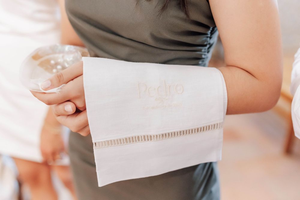 Close-up detail of someone holding a white decorative cloth napkin.