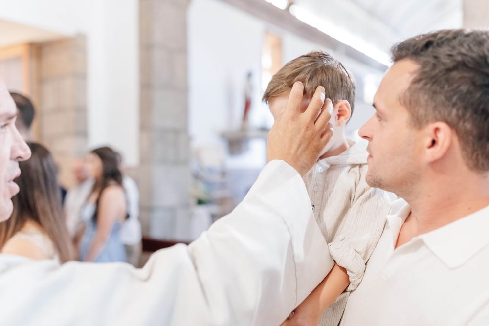 A tender religious ceremony moment captured in soft natural light.