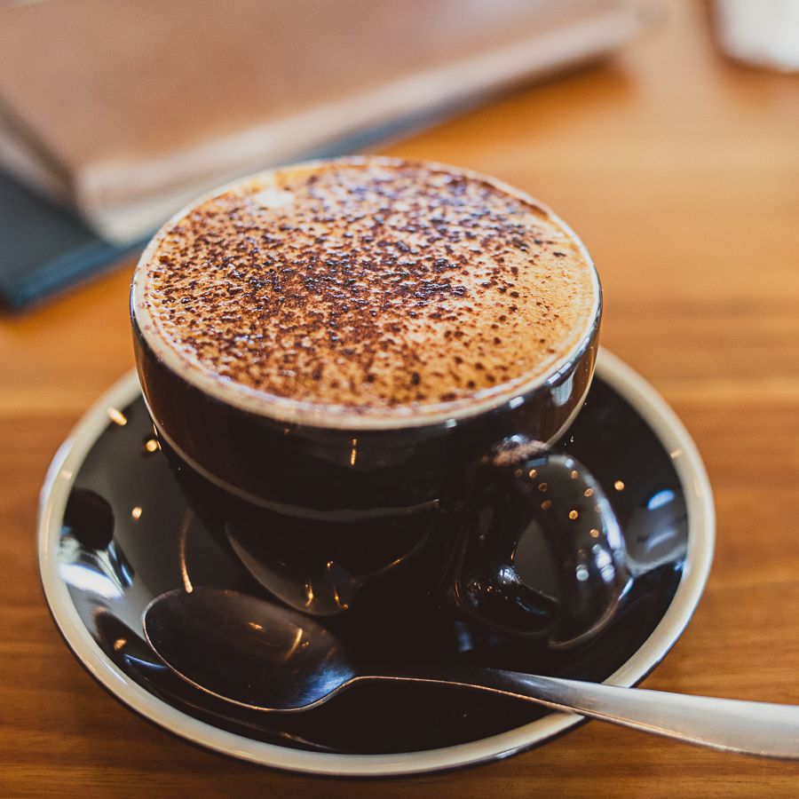 Cappuccino cuppa in a black cup (Coffee shot captured by Lesley Marks)