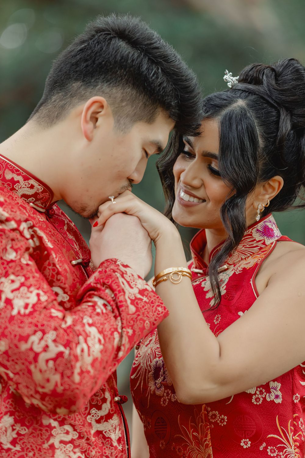 Intimate moment between couple wearing matching red traditional Chinese wedding attire.