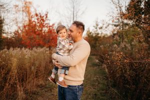 An adult and child share a moment together on an autumn nature path.