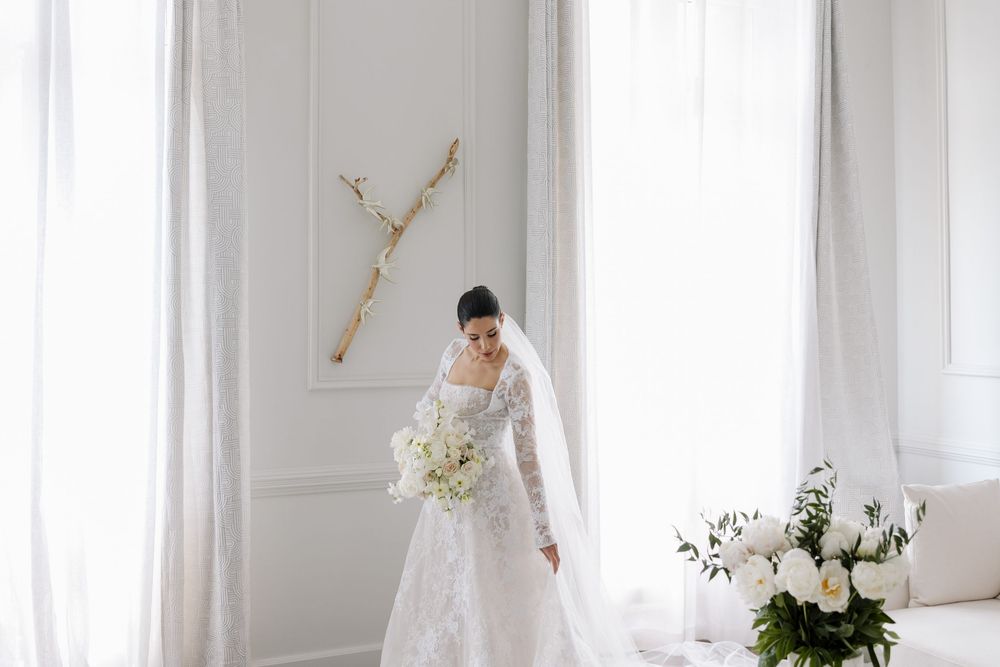 Minimalist bridal portrait in a bright white room with delicate lace details and natural light.