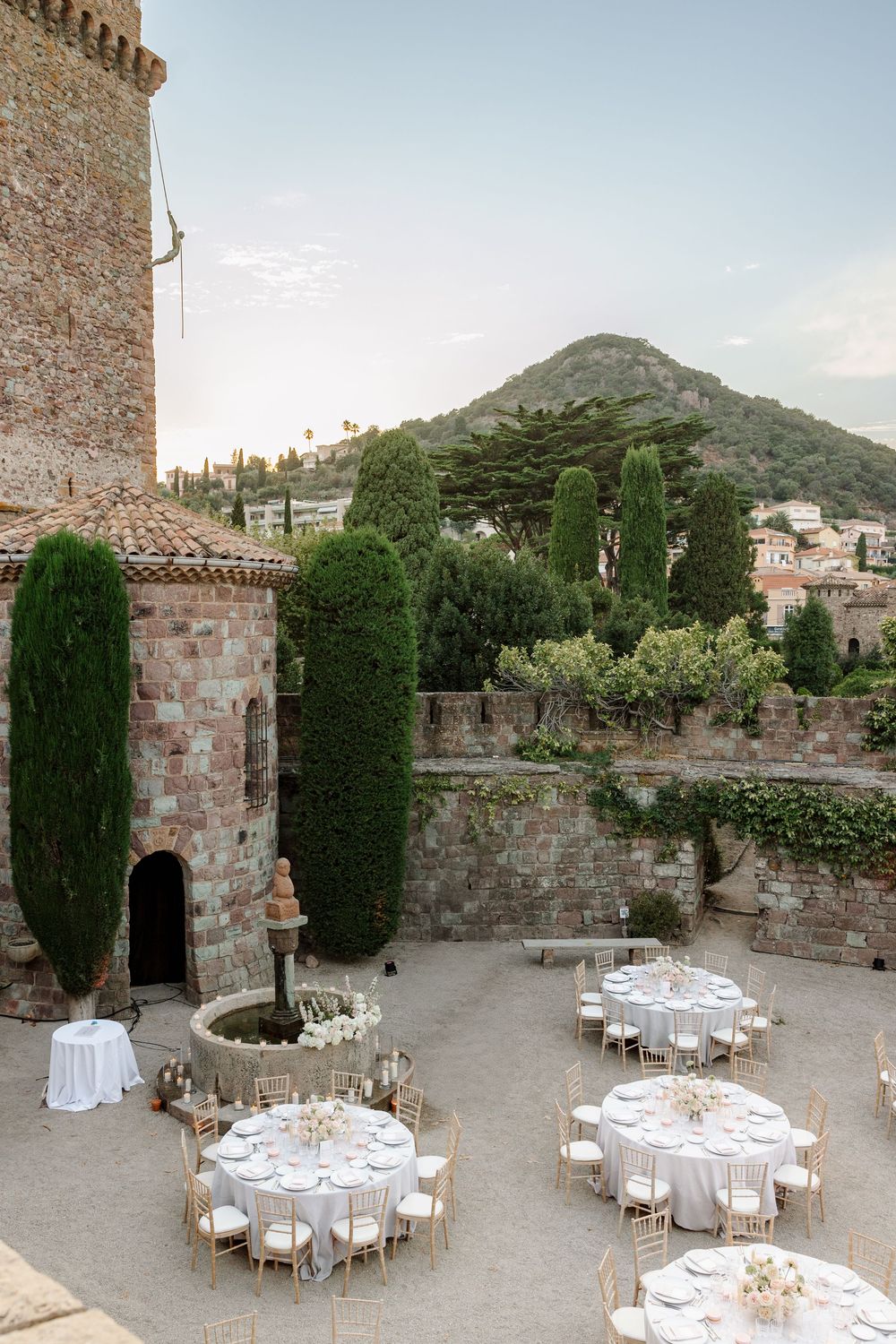 Stone castle courtyard set for an intimate outdoor wedding reception with mountain views.
