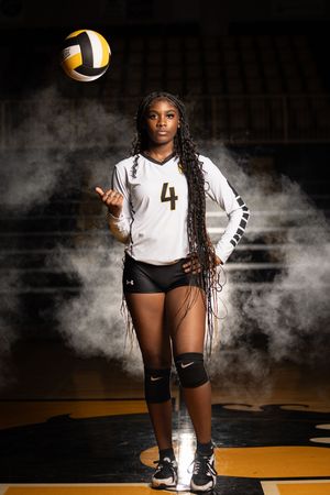 Dramatic volleyball player photo series featuring team member in black and white uniform against smoky backdrop.
