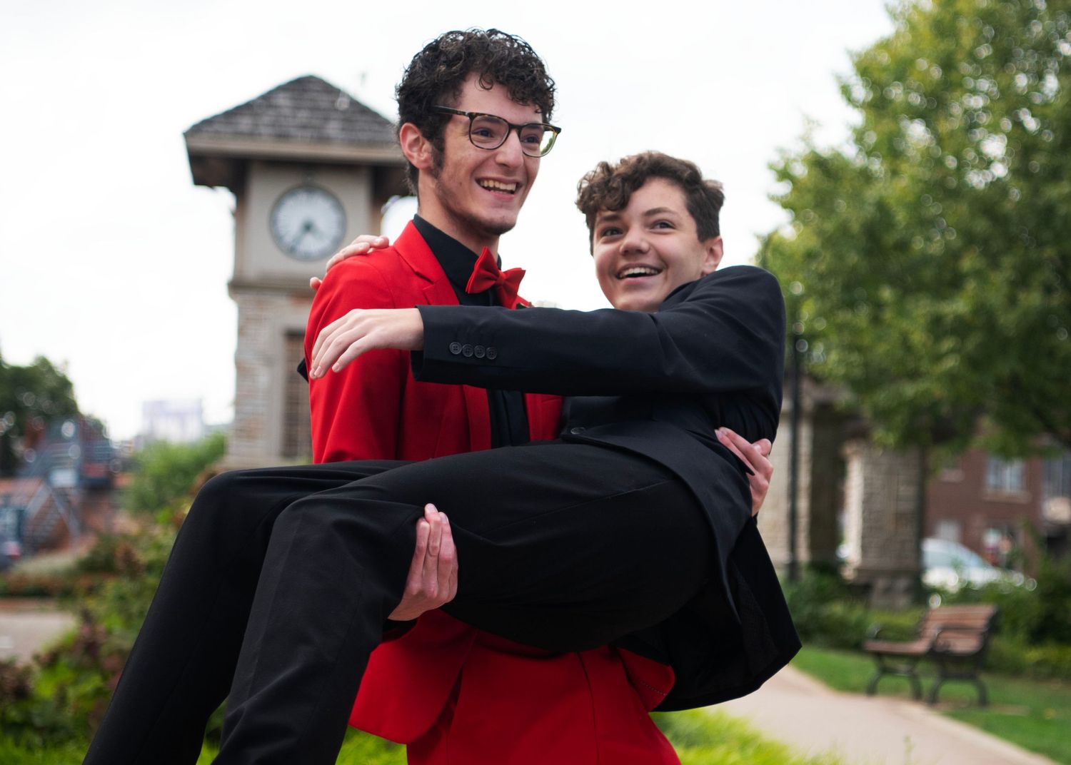 Samuel holding Oliver dressed in suits for homecoming