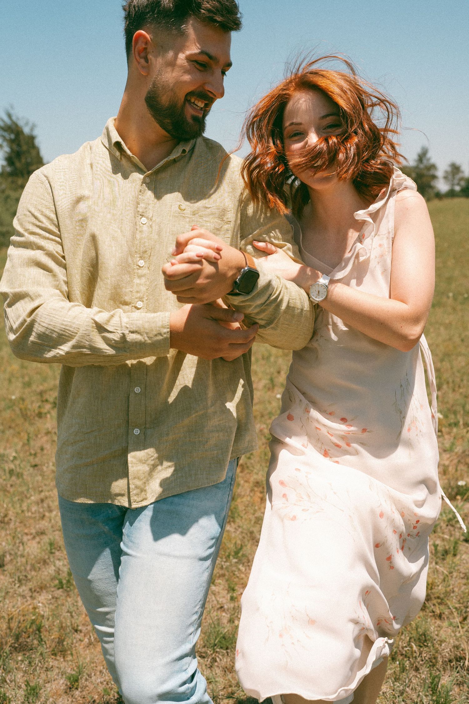 Candid moments of joyful dancing and laughter in a summer field.