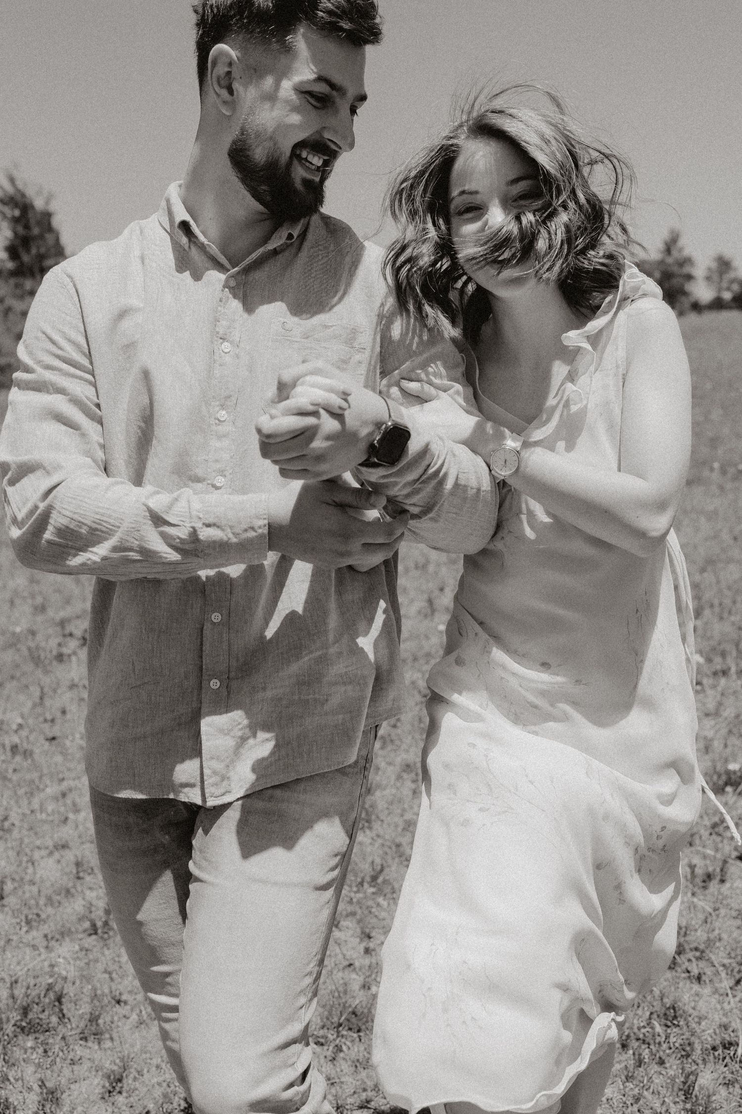 Black and white capture of genuine laughter and connection during an outdoor dance.