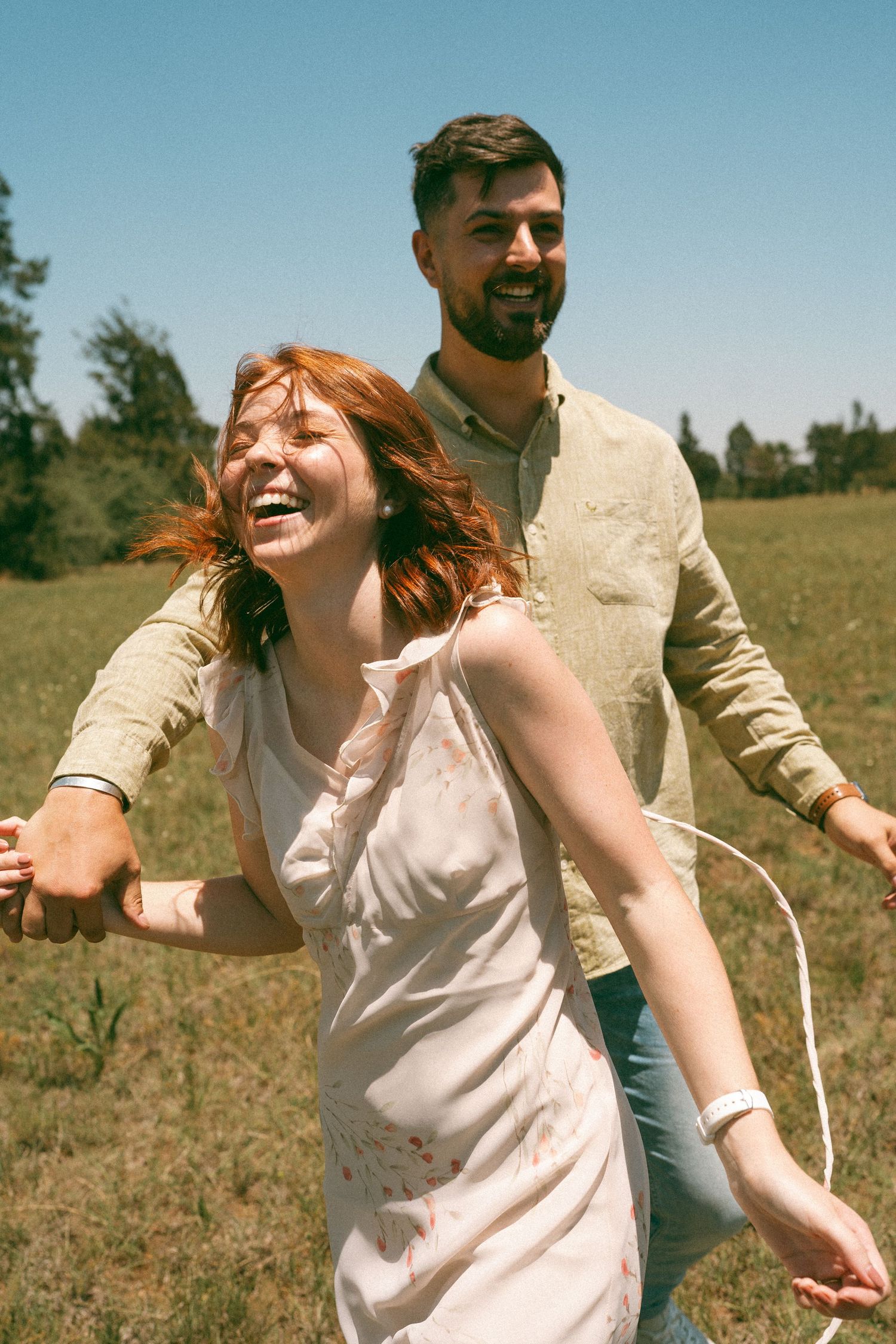 A joyful dance sequence captured in a sun-drenched field.