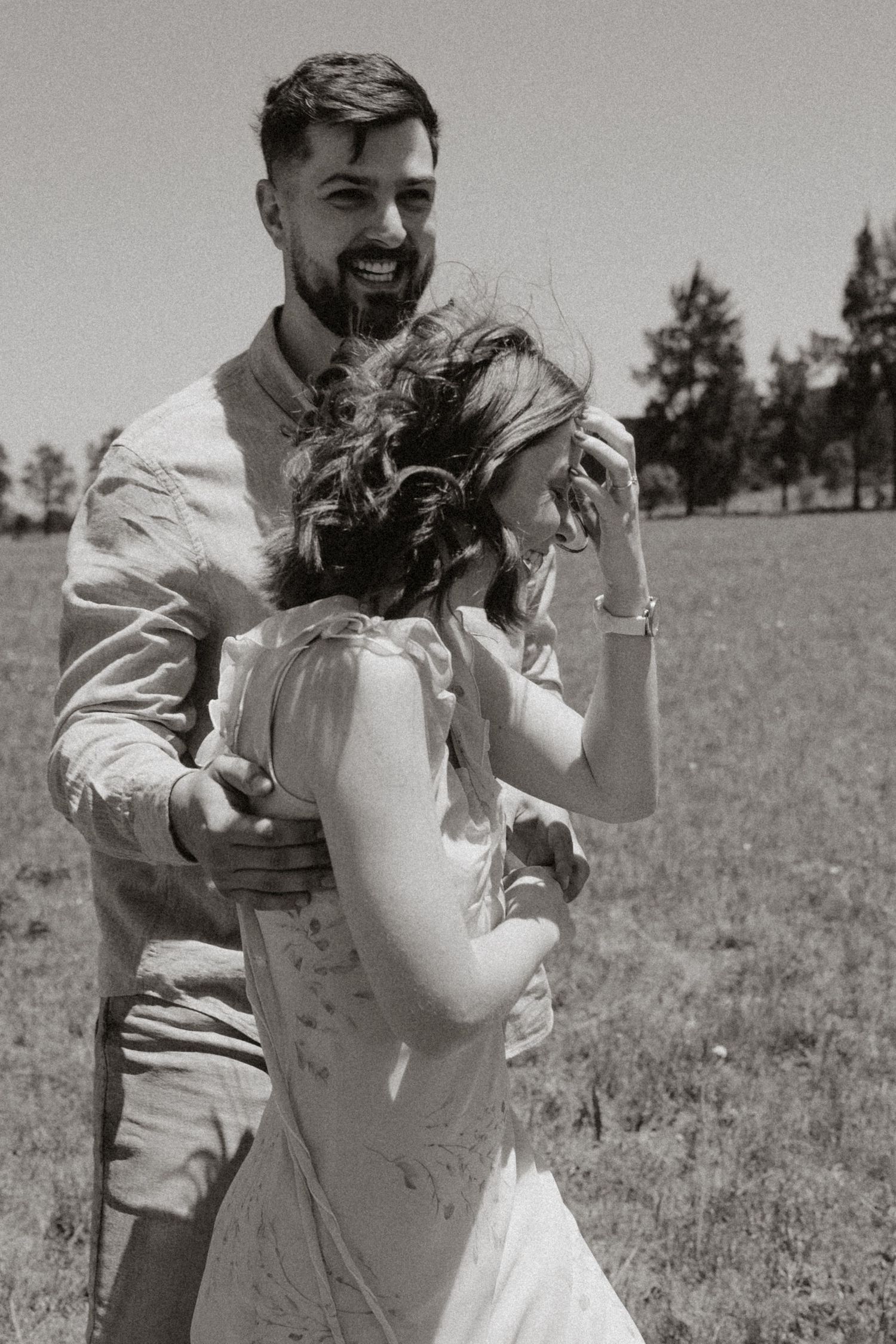 A black and white photo capturing a playful dance moment outdoors.