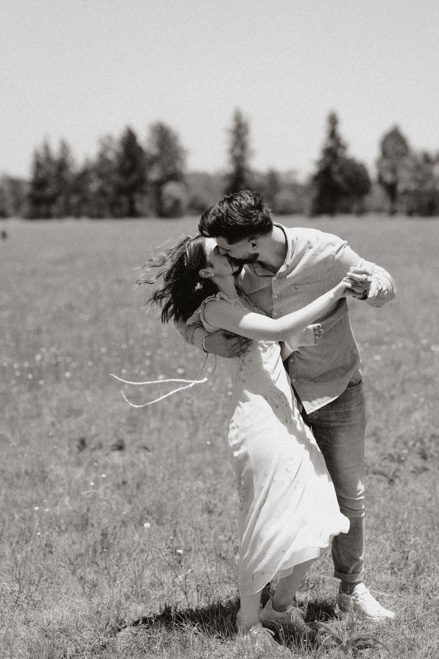 Black and white photo of a romantic dance dip in a wildflower field on a summer day.
