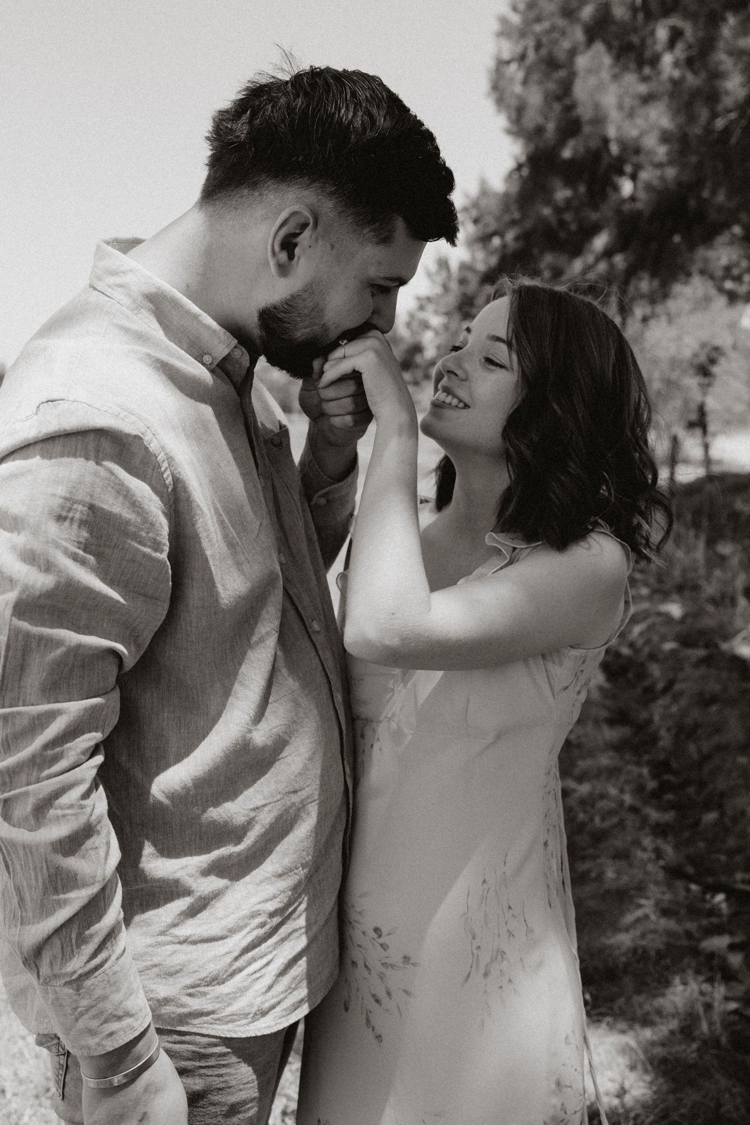 Romantic black and white portrait of a couple sharing an intimate moment outdoors.