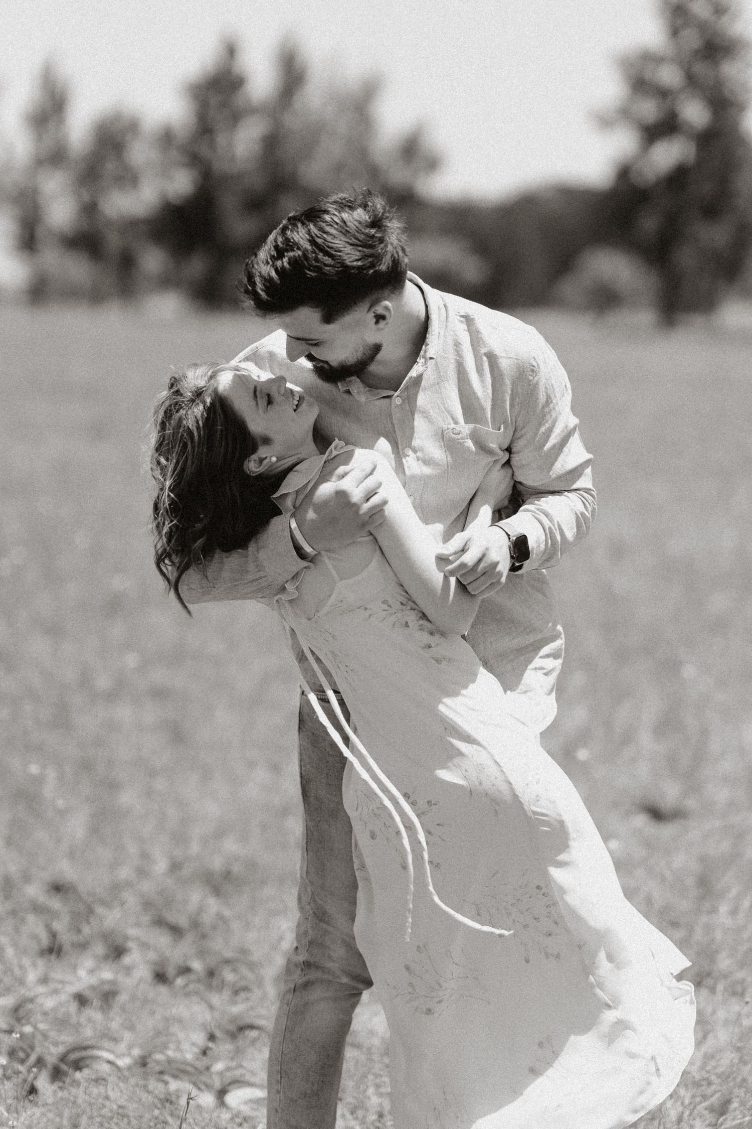 Intimate black and white portrait of a dance dip against a natural outdoor backdrop.