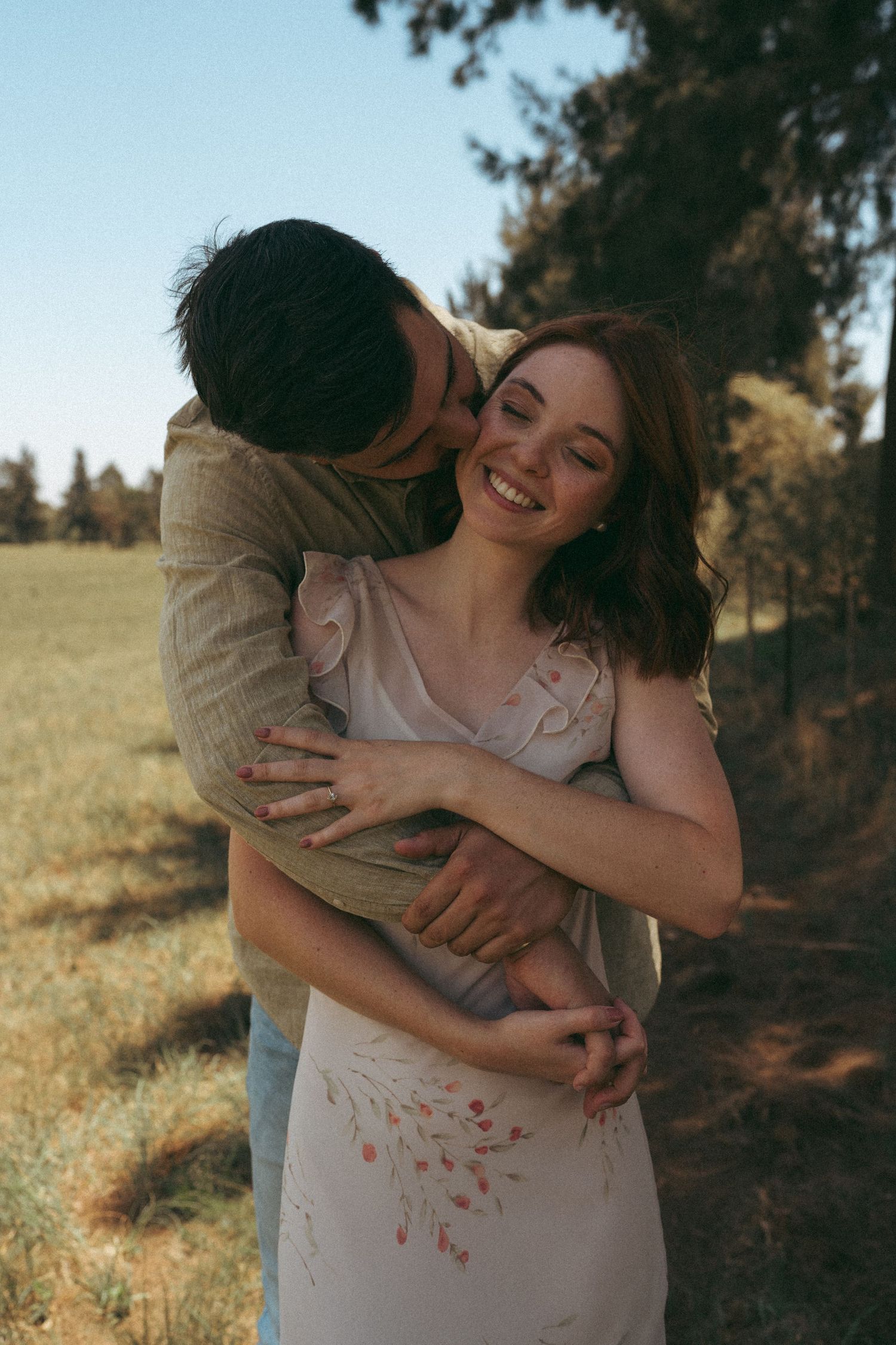 Candid moments of laughter and hugs between a couple in natural lighting.