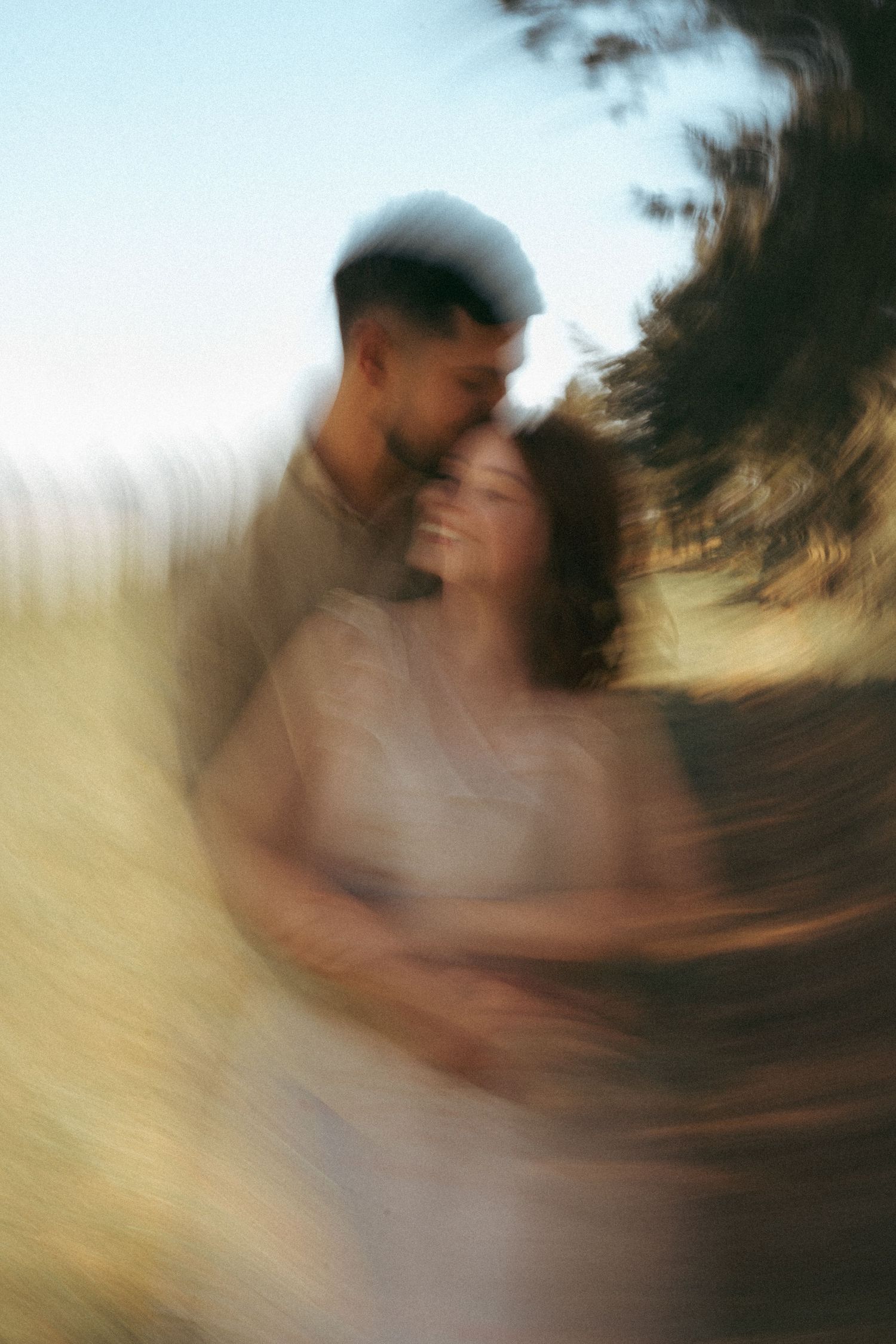 Artistic motion blur sequence of a couple embracing in golden sunlight.