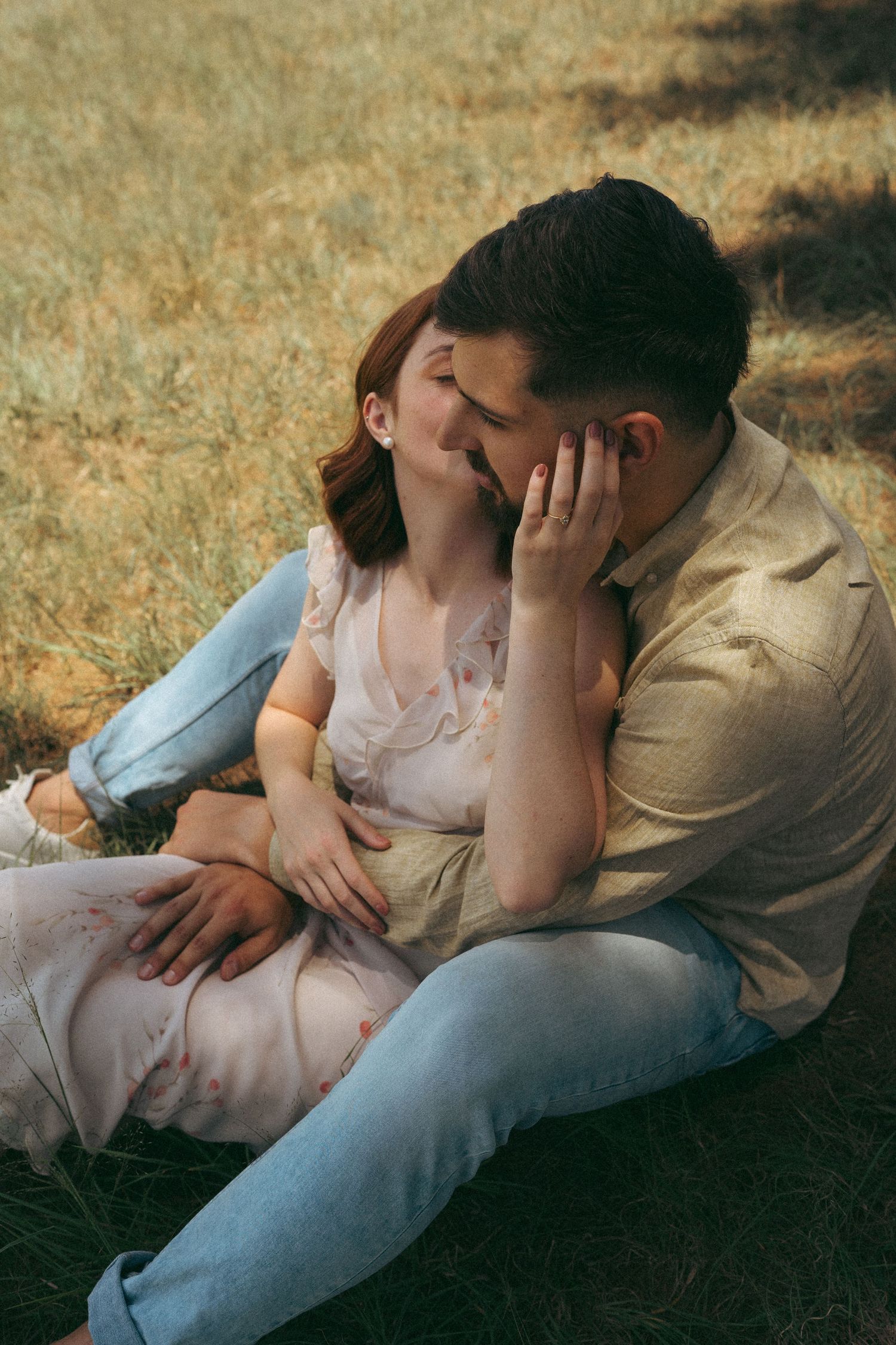 Intimate sequence of couple sharing tender moments while lying in golden grass.