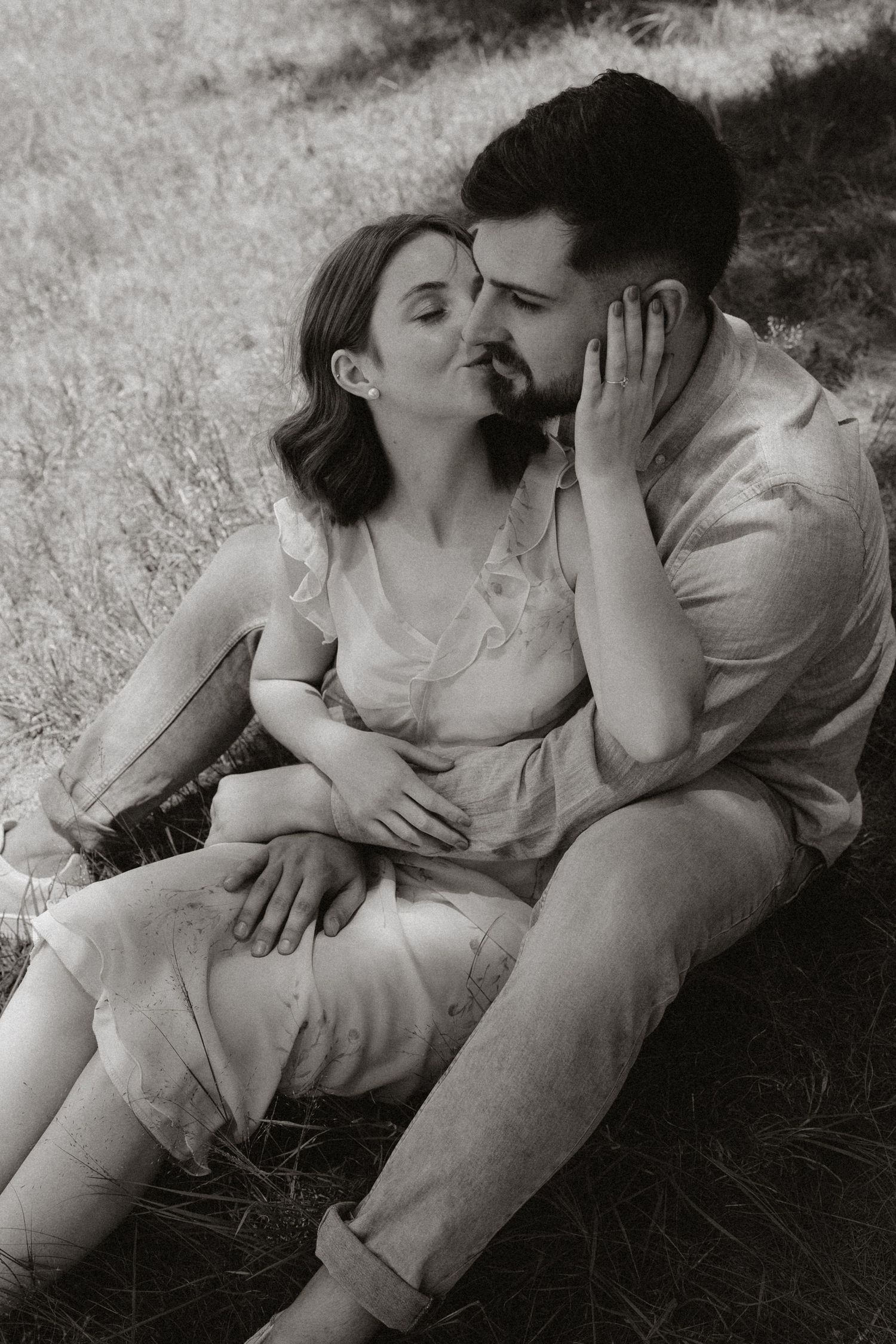 Black and white sequence capturing intimate moments between couple on grass.