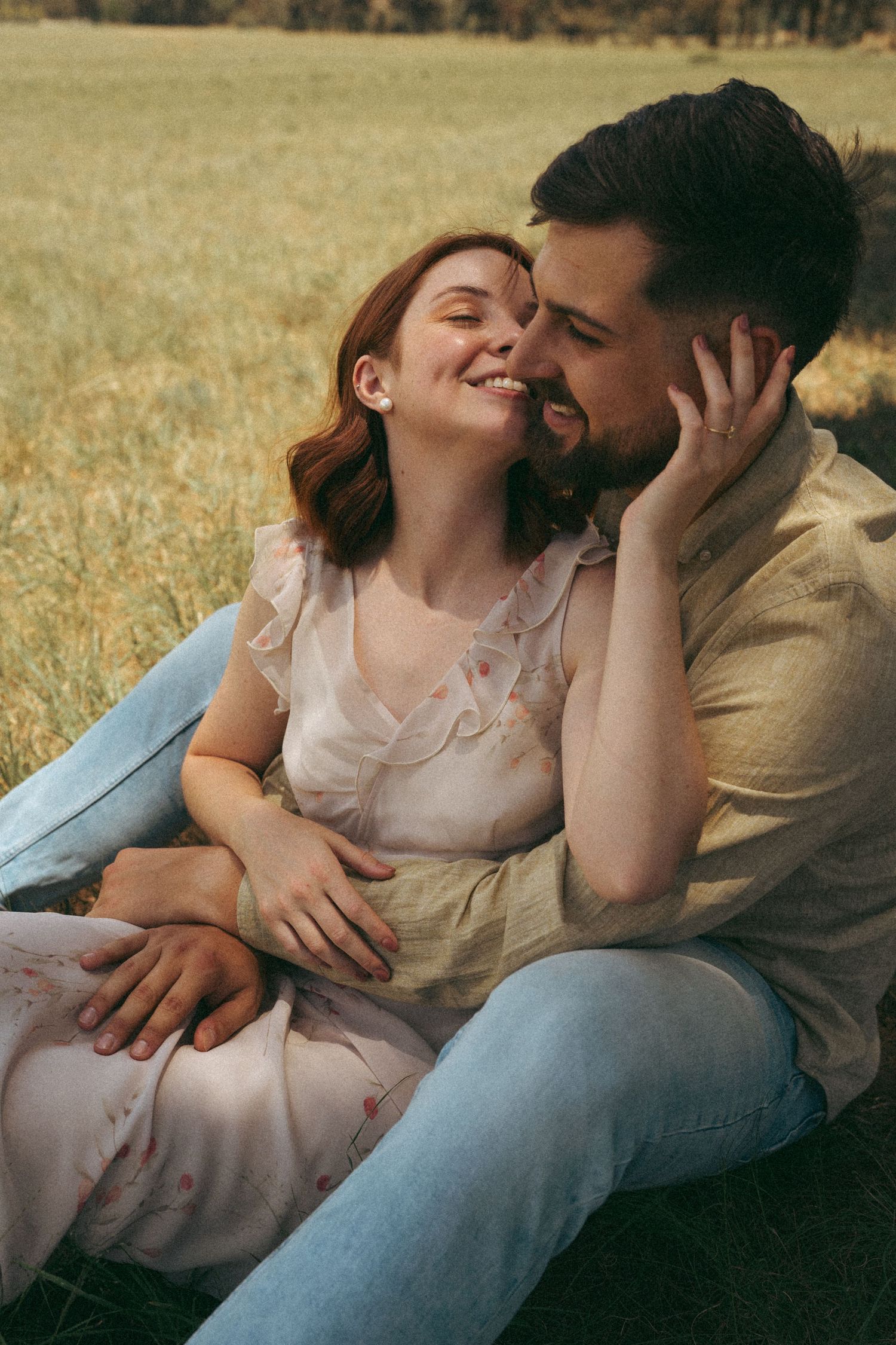 Romantic sequence showing tender moments between couple on grassy hillside at sunset.