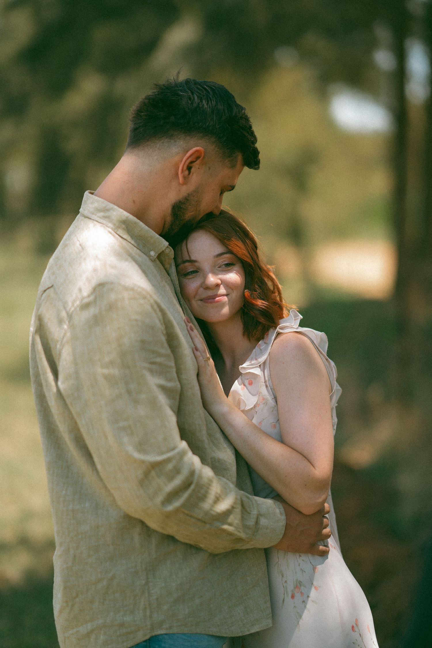 Warm-toned intimate portrait of a tender moment between two people in nature.