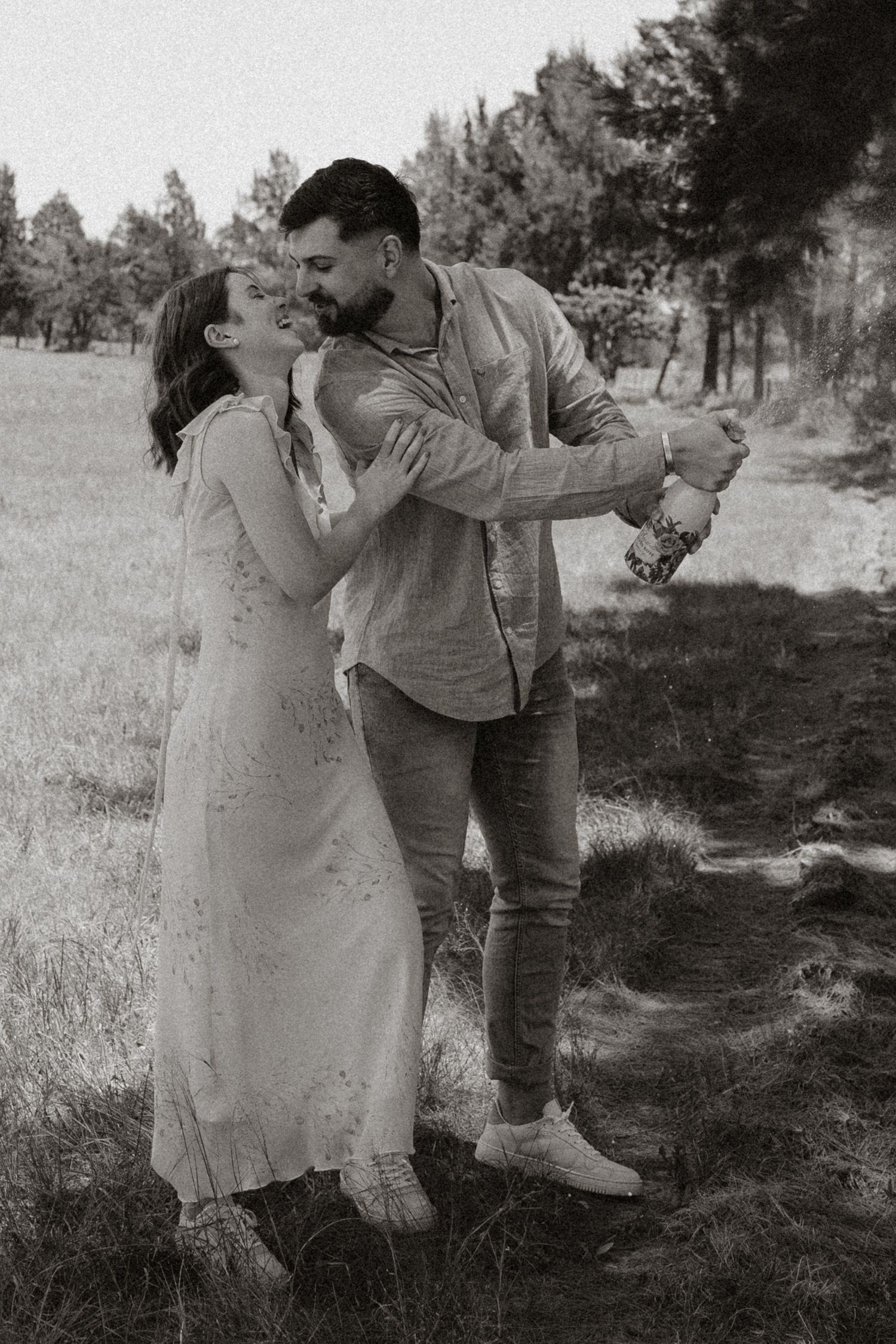 A black and white photo capturing a romantic dance moment outdoors.