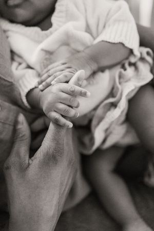 A collection of black and white images showing tender close-up shots of holding hands and gentle touch moments.