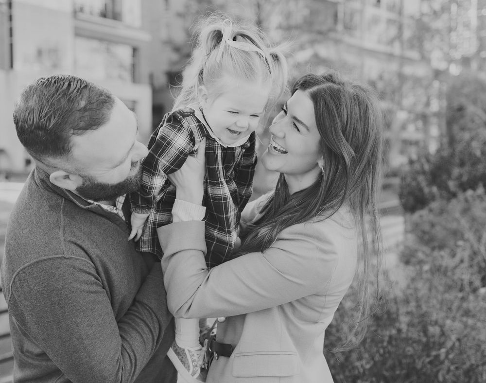 Family shares joyful moment together during black and white portrait session.