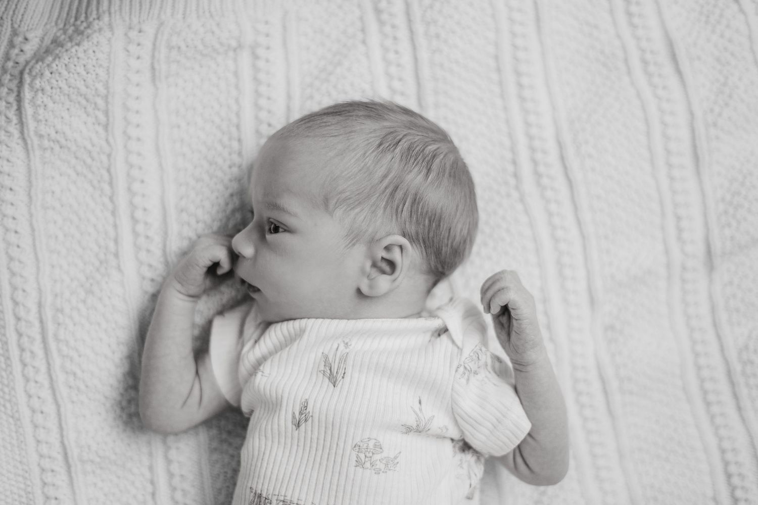 Serene newborn photography captured in a Grand Rapids studio, featuring a peaceful baby posed delicately, perfect for newborn portraits.
