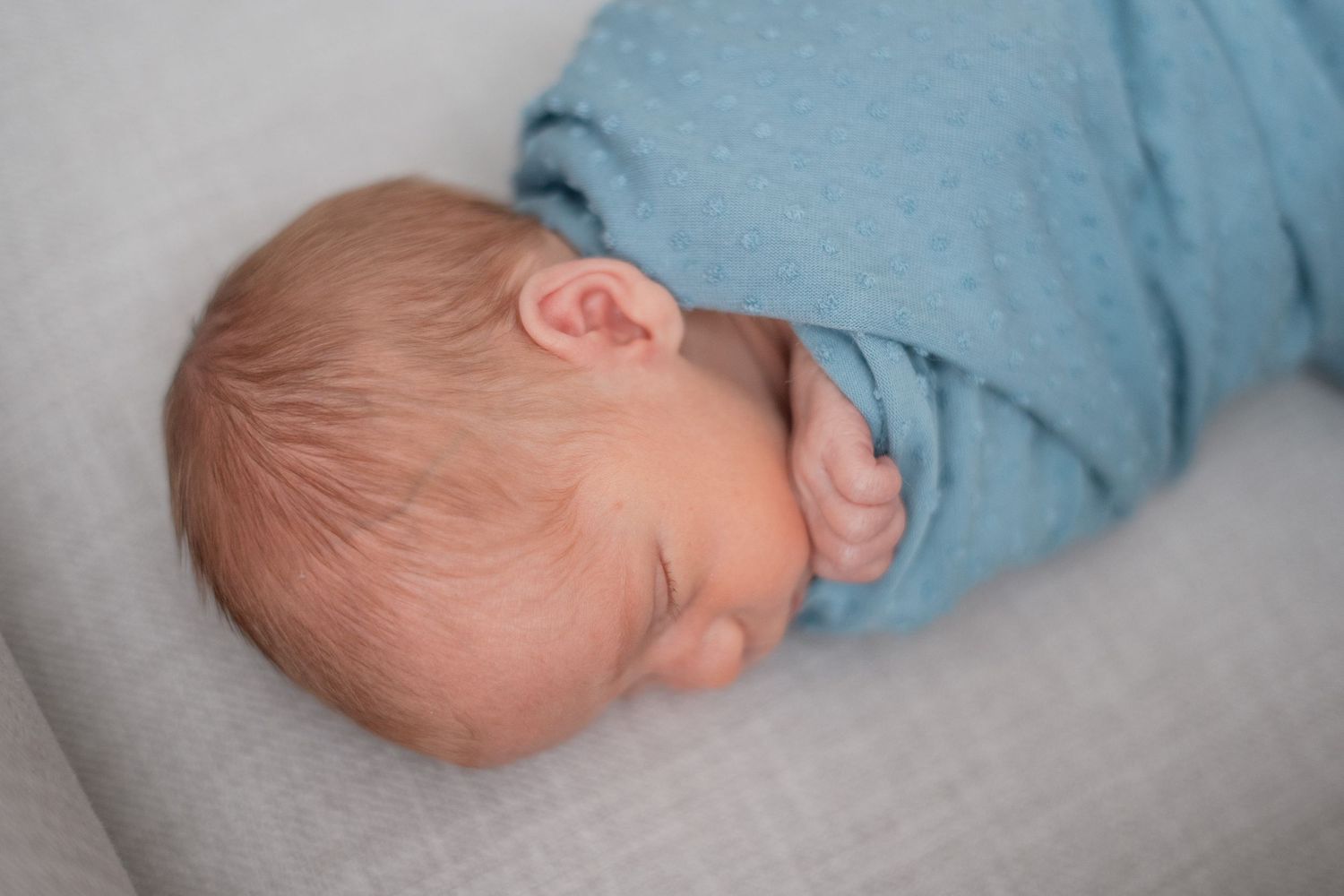 Serene newborn photography captured in a Grand Rapids studio, featuring a peaceful baby posed delicately, perfect for newborn portraits.