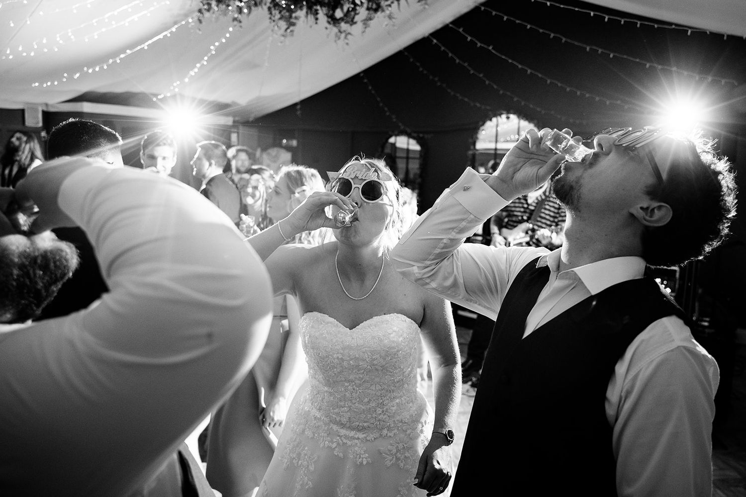 Black and white photos of a wedding reception dance floor with dramatic lighting effects.