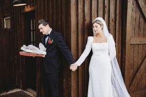 Elegant first look wedding photos captured against a rustic wooden barn backdrop.
