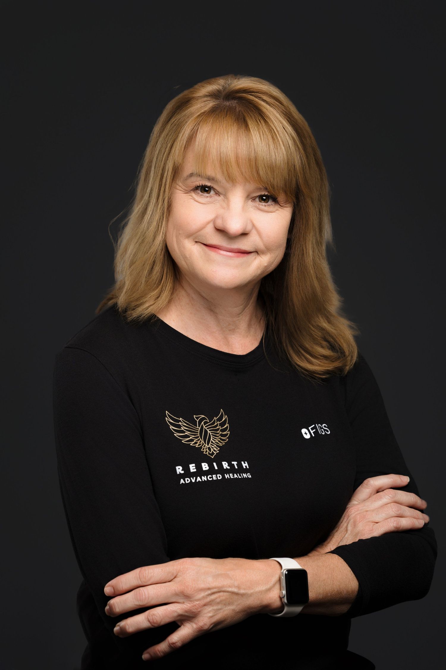 Professional studio portraits on black background showing a person in black attire with a decorative brooch.