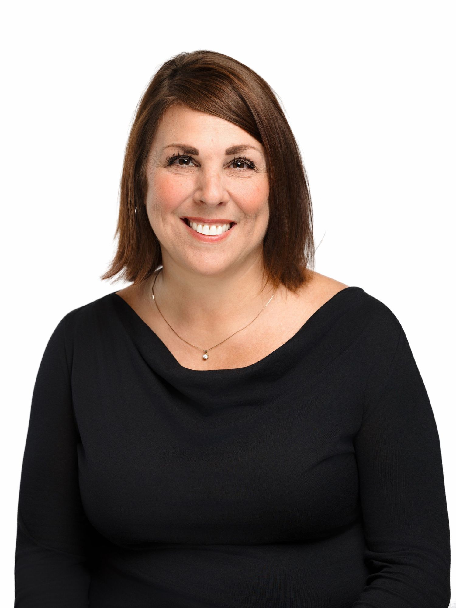 Professional headshot portrait of someone wearing a black top against white background smiling warmly.