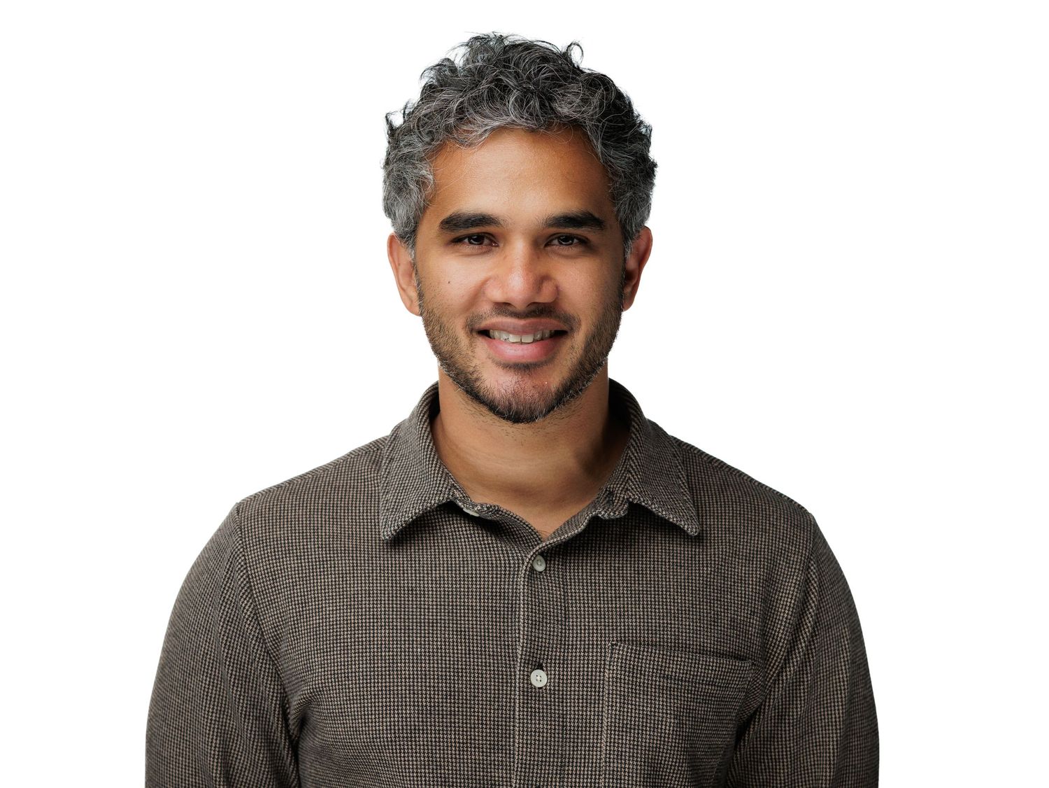 Smiling man with curly gray hair wearing a brown polo shirt against a white background.