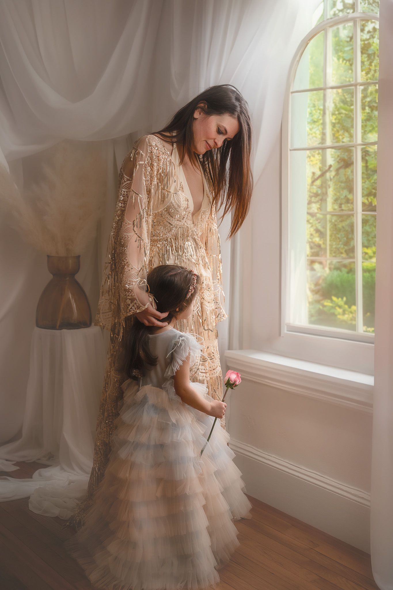 Mother and daughter sharing an intimate moment by a window with ethereal white curtains in the Hudson Valley,NY.