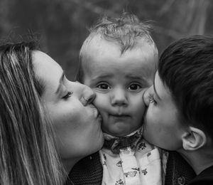 Mom and son kissing the baby